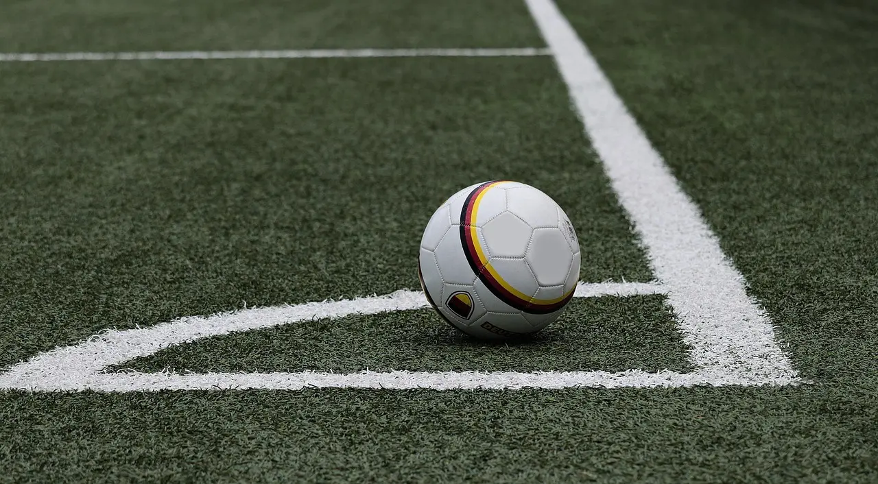 Fodbold placeret på hjørnemærket på en kunstgræsbane